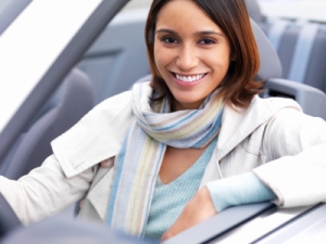 Closeup of a young smiling woman sitting in car